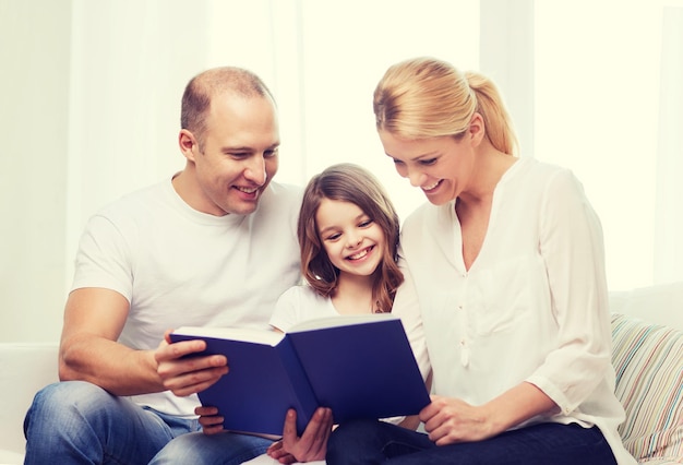 Photo family, child and home concept - smiling parents and little girl with book at home