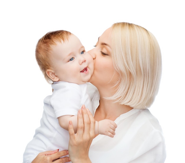 Concetto di famiglia, bambino e genitorialità - madre felice che bacia bambino sorridente