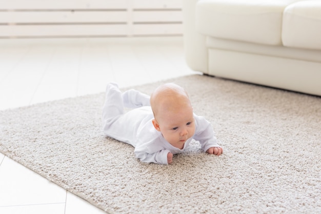 Family, childhood concept - Close up portrait of pretty baby lie on the floor