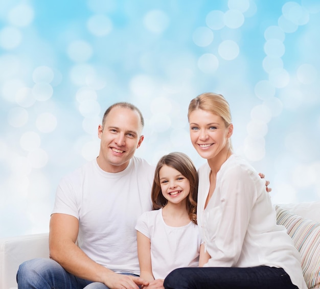 family, childhood, holidays and people - smiling mother, father and little girl over blue lights background