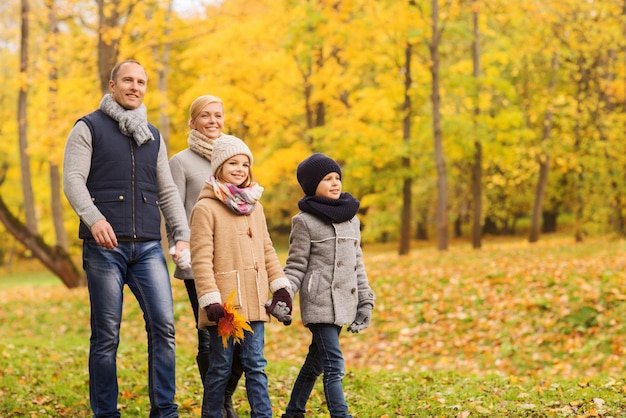 family, childhood, season and people concept - happy family in autumn park