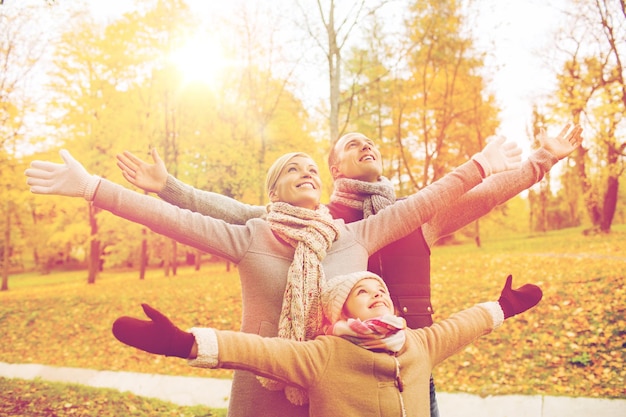 family, childhood, season and people concept - happy family having fun in autumn park