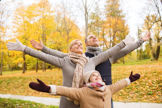 family, childhood, season and people concept - happy family having fun in autumn park