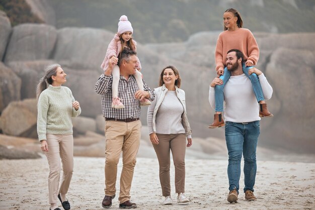 Family children and beach with grandparents parents and grandkids walking on the sand at the coast together Summer travel and love with a man woman and kids bonding on a coastal walk outdoor