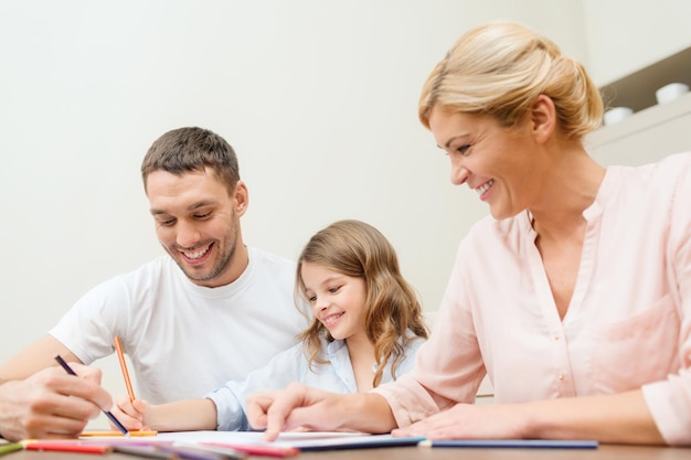 family, children and happy people concept - happy family drawing at home