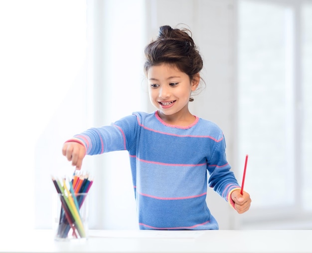 family, children and happy people concept - little girl drawing