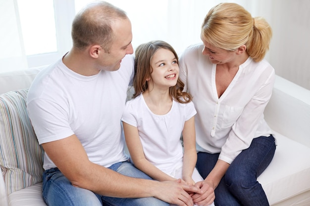 family, children and people concept - happy parents with little daughter at home