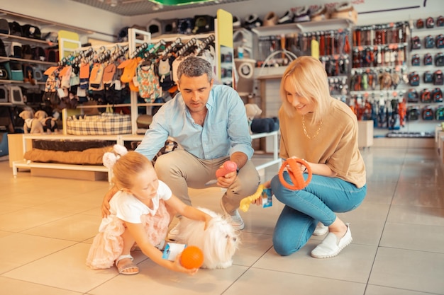 Family choosing toys for their pet while visiting pet shop