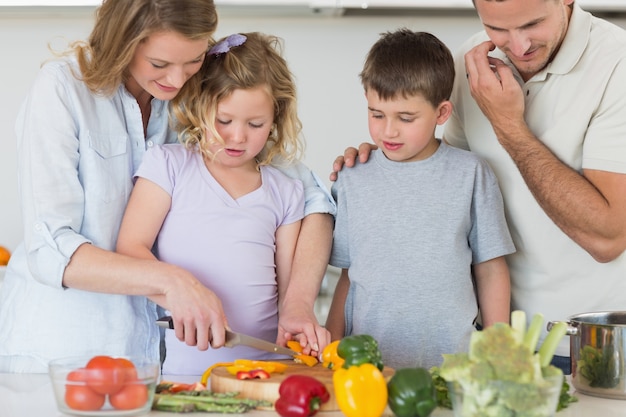 Family chopping vegetables in kitchen