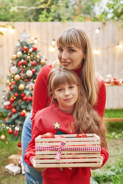 Family Christmas in July Portrait of girl near christmas tree with gifts Decorating pine Winter