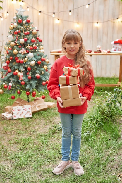 7月の家族のクリスマスプレゼントとクリスマスツリーの近くの女の子の肖像画