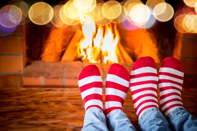 Family in Christmas socks near fireplace. Mother; father and baby having fun together. People relaxing at home