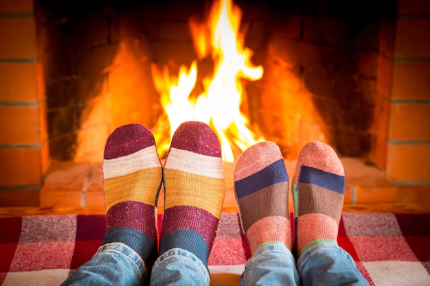 Family in Christmas socks near fireplace. Mother; father and baby having fun together. People relaxing at home