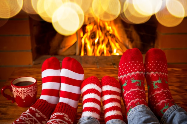 Family in Christmas socks near fireplace