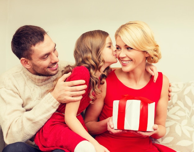 家族、クリスマス、クリスマス、幸福、人のコンセプト – 愛らしい子どもが母親にキスをし、プレゼントを贈る