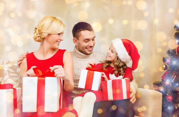 family, christmas, x-mas, winter, happiness and people concept - happy family opening gift boxes