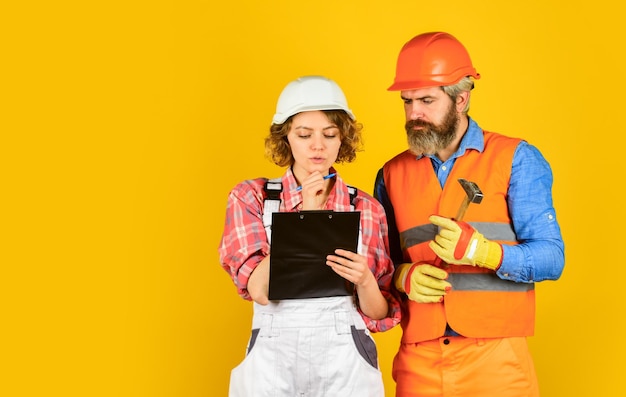 Family counting finances for renovation. renovation concept. couple planning changes renovation apartment. couple looking at documents. woman and man wear safety hard hat. redevelopment of home