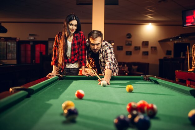 家族のカップルはビリヤードルームで遊ぶ