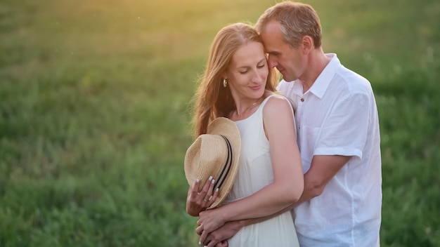 Family couple shows love to each other hugging on meadow