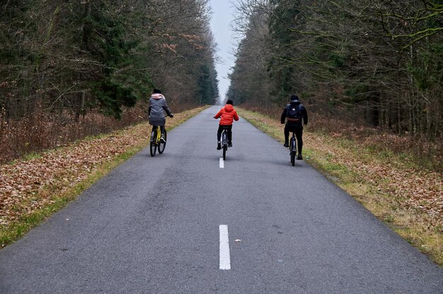 Family cycling in autumn park Dad Mom son