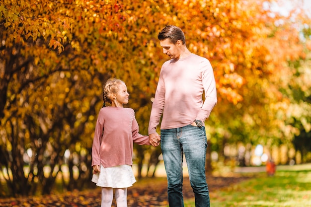 Family of dad and kid on beautiful autumn day in the park