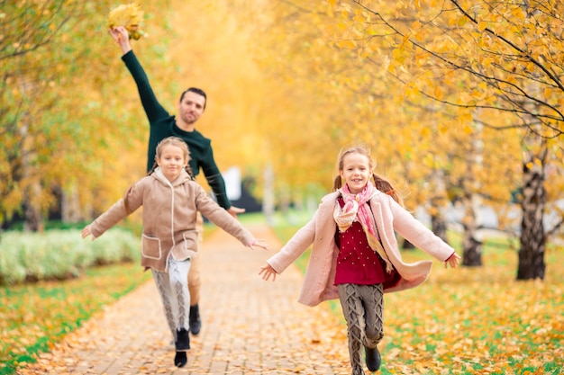 Family of dad and kids on beautiful autumn day in the park