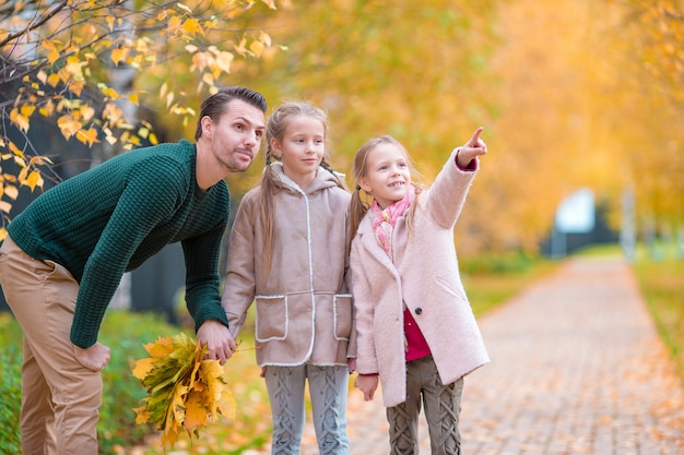 Family of dad and kids on beautiful autumn day in the park