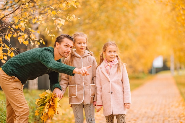 Family of dad and kids on beautiful autumn day in the park