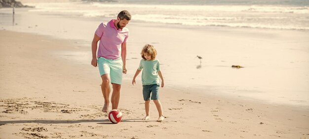 ビーチの幸せでボールを遊んでいるパパの男と子の男の子の家族