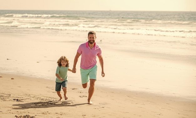 Family of daddy man and child boy running on beach vacation