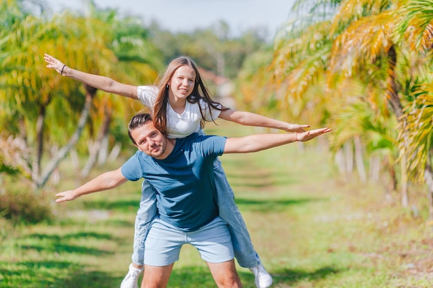 Family of daughter and father having fun among palm trees on vacation family vacation