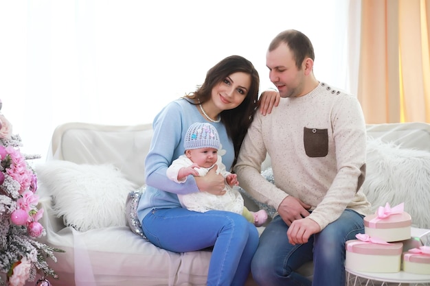 Family decorating beautiful live Christmas tree Loving family with presents in room Happy family on holidays