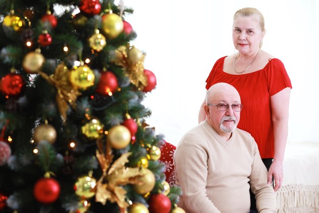 Family decorating beautiful live Christmas tree Loving family with presents in room