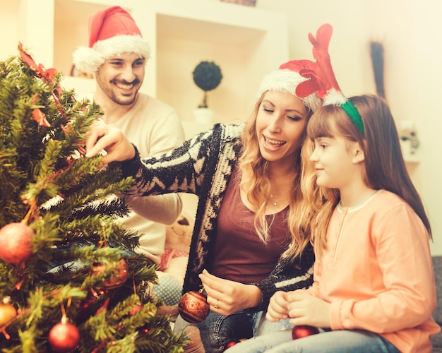 Premium Photo | Family decorating christmas tree