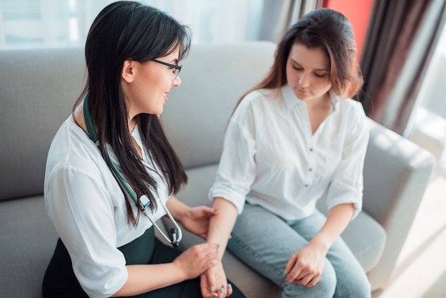 Family doctor check heart rate of a young mother