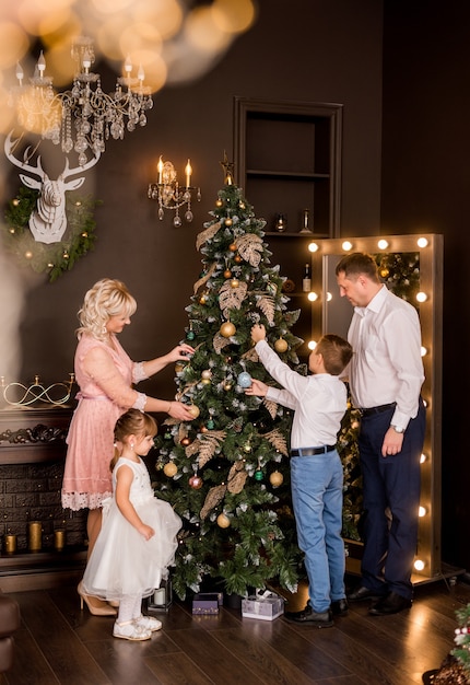 Family dresses up a Christmas tree. Preparing for the New Year.