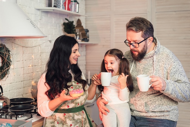 The family drinks tea and eats donuts