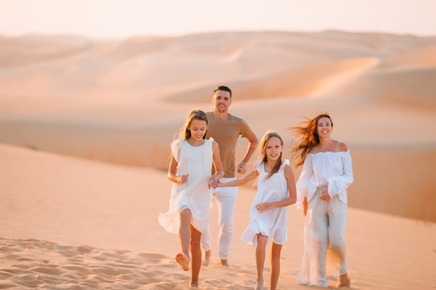 Family among dunes in Rub al-Khali desert in United Arab Emirates