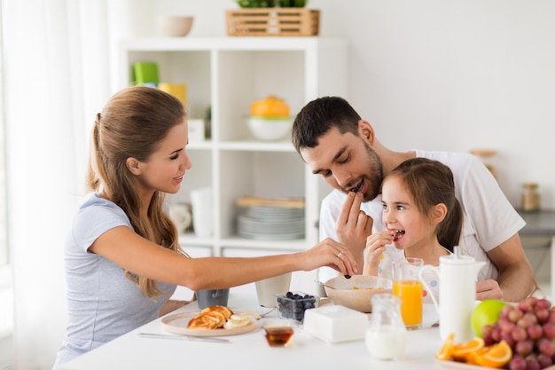 Foto famiglia mangiare e persone concetto madre felice padre e figlia fare colazione a casa