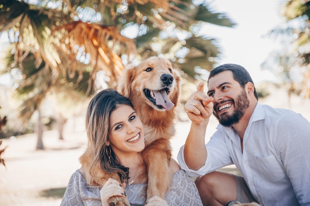 Family enjoying a sunny day in the park with their pet.