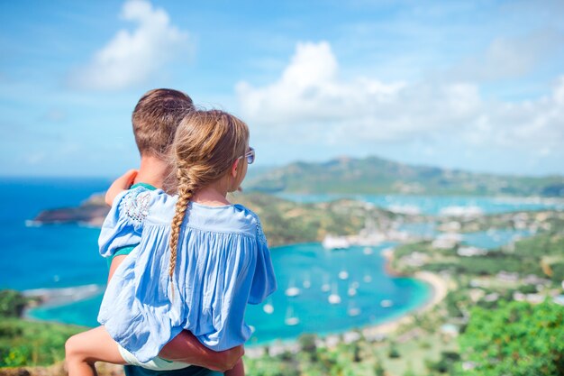 Семья, наслаждаясь видом на живописную английскую гавань в Антигуа в Карибском море