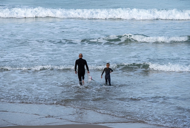 family entering the sea to surf