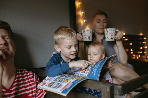 family evening before christmas reading a book and drink hot chocolate together