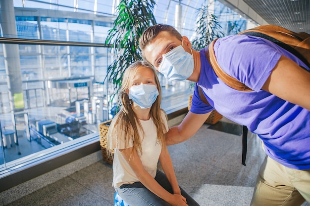 Family in face mask in airport. Father and child wear facemask during coronavirus and flu outbreak