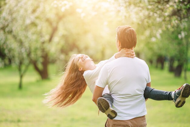 Family of father and daughter in blooming cherry garden