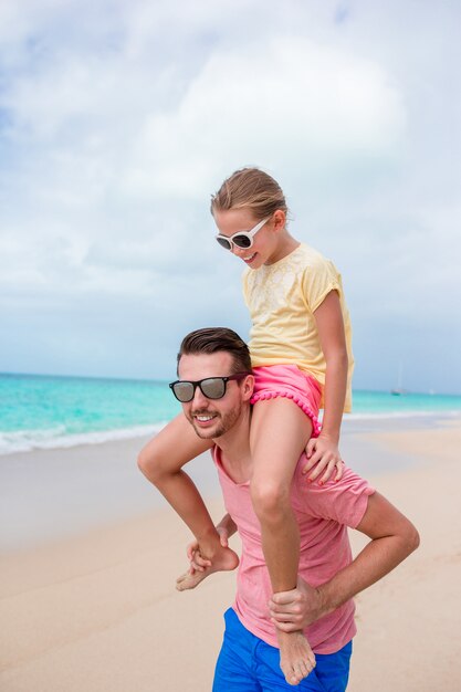 Family of father and sporty little girl having fun on the beach