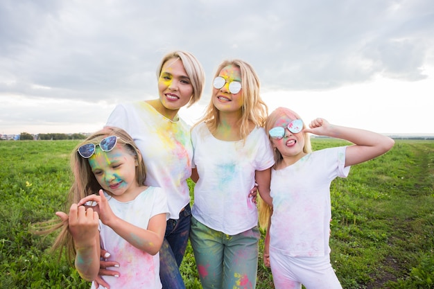 Photo family, festival of holi and holidays concept - close up portrait of happy family covered in paint.