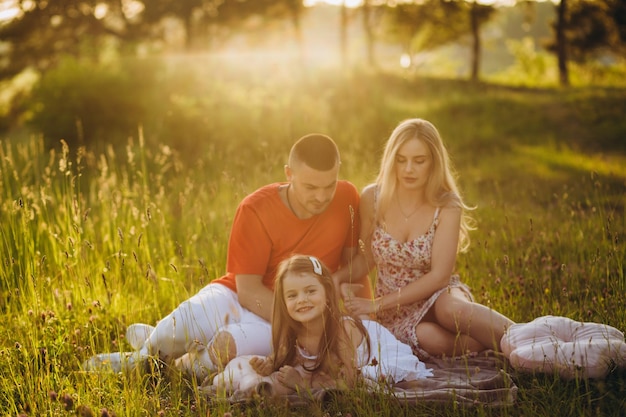 Photo family in a field walking at sunset