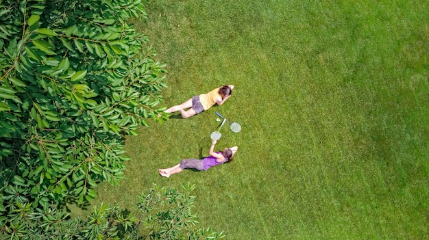 Family fitness and sport active mother and daughter teenager playing shuttlecock in park