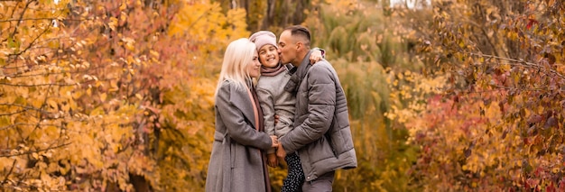 A Family of four enjoying golden leaves in autumn park